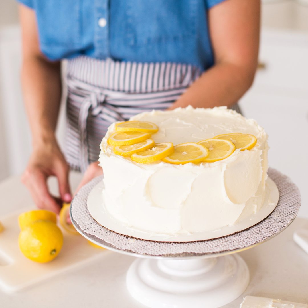 Chocolate Zucchini Cake on a turntable with lemons.