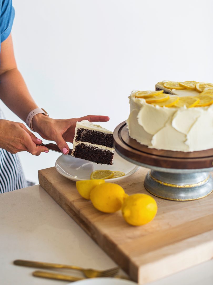 Woman placing cake slice on a plate. 