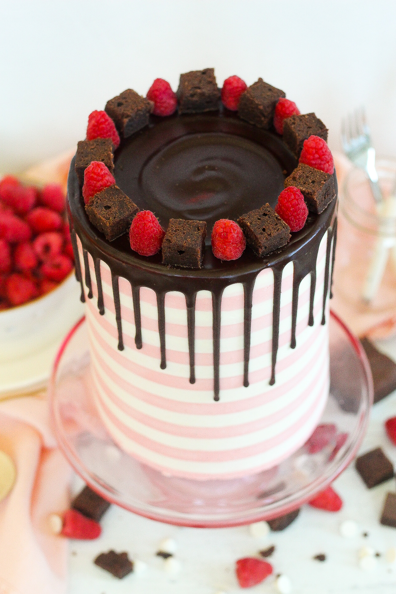 Fully decorated cake with pink and white stripes and chocolate ganache. 