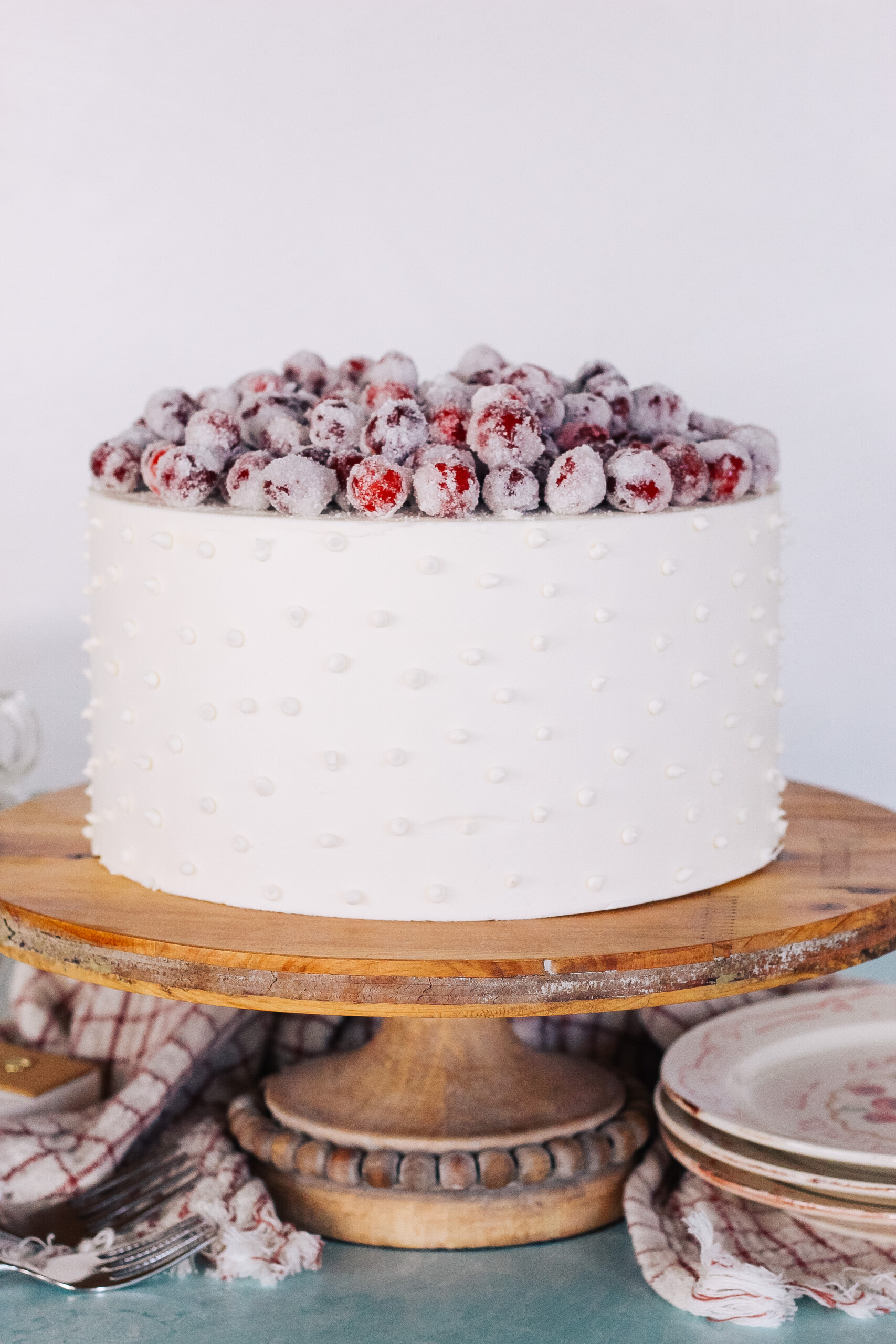 Cake on a cake stand with candied cranberries.