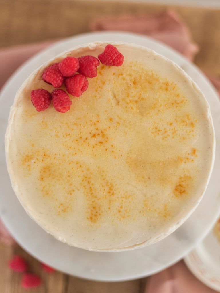 Creme Brûlée Cake: vanilla bean cake layers baked on a graham cracker crust, filled with vanilla bean custard and covered in a vanilla bean buttercream #cakebycourtney #cake #cremebrulee #cremebruleecake #cakerecipe #vanillabeancake #vanillacake
