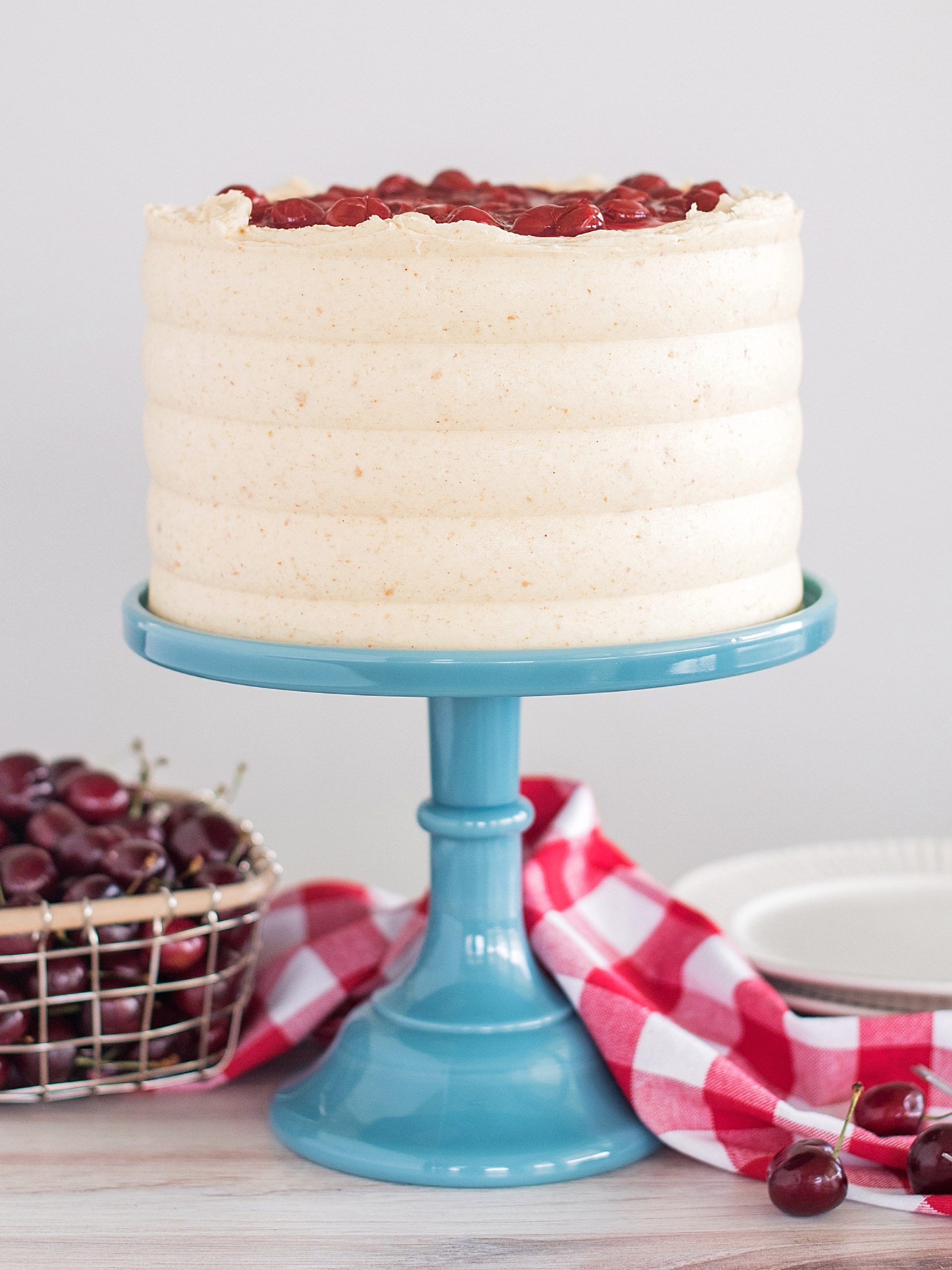 A cherry cheese pie cake on a blue cake stand.