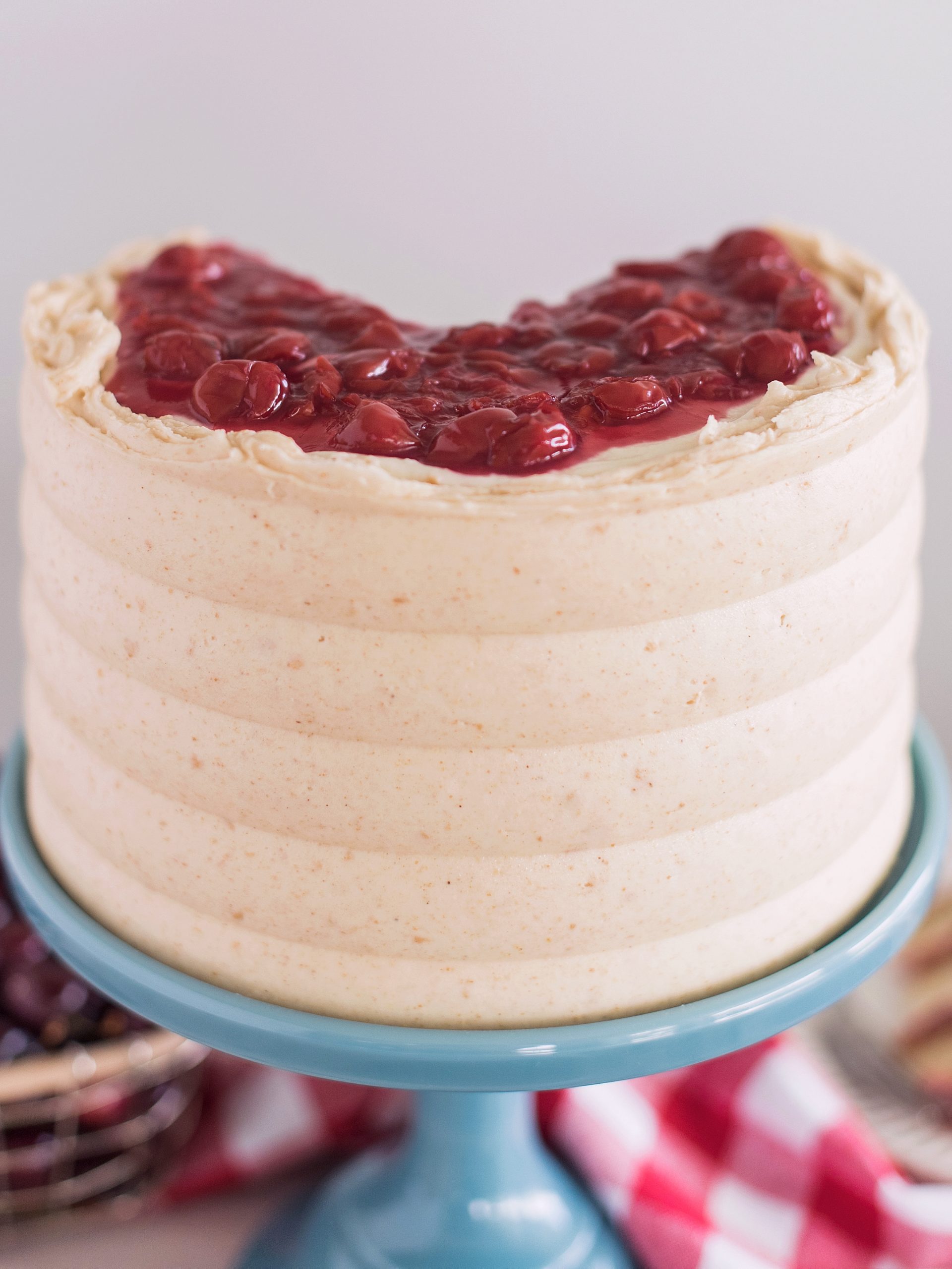 A cherry cake on a cake stand.
